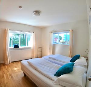 a bedroom with a large bed with two windows at Pearl of the North Apartments in Akureyri