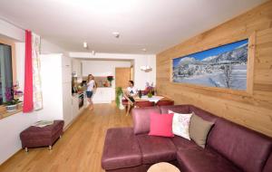 Appartements Kolb في توبليتز: غرفة معيشة مع أريكة أرجوانية ومطبخ
