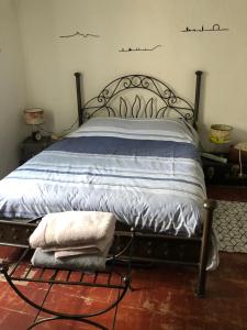 Bett mit Metallrahmen und Handtüchern darauf in der Unterkunft Mon Abri in Garéoult