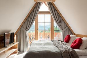 sypialnia z łóżkiem i dużym oknem w obiekcie Apartamenty Franka Zakopane w mieście Kościelisko