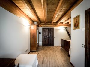 Cette chambre est dotée d'un plafond en bois et d'une porte. dans l'établissement Agriturismo Piane, à Ono Degno