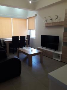 a living room with a television and a table at Plakoures Home in Kounoupidhianá