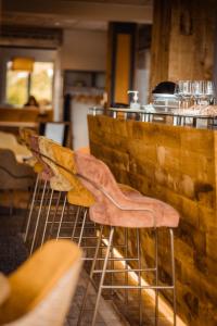 una fila de taburetes en un bar en un restaurante en Hôtel du Bollenberg - Restaurant "Côté Plaine" - Spa de la Colline, en Westhalten