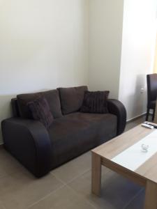 a brown couch in a living room with a table at Plakoures Home in Kounoupidhianá