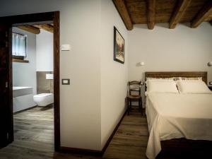a bedroom with a bed and a bathroom at Agriturismo Piane in Ono Degno