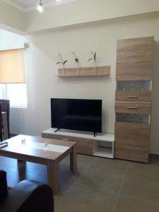 a living room with a television and a coffee table at Plakoures Home in Kounoupidhianá