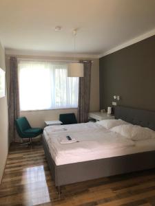 a bedroom with a bed and two chairs and a window at Asiatisches Landhaus in Braunsbedra