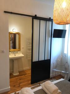 La salle de bains est pourvue d'une porte noire et d'un lavabo. dans l'établissement Maison Caju - La Rochelle, à La Rochelle