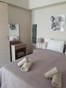 a bedroom with a bed with towels on it at Plakoures Home in Kounoupidhianá