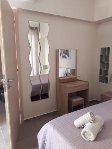 a bedroom with a bed and a mirror on the wall at Plakoures Home in Kounoupidhianá