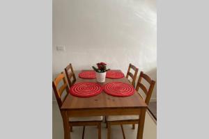 uma mesa de madeira com placas vermelhas e um vaso de flores em Casa del Sole em Tollo