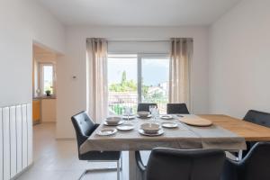 a dining room with a wooden table and chairs at Apartman Justina Medulin for 2 person in Medulin