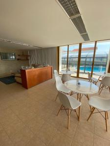 a room with a table and chairs and a kitchen at Buarcos Luxury Guest house in Figueira da Foz