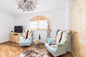 uma sala de estar com duas cadeiras e uma mesa em Zasypane Premium House & Sauna in Zakopane by Renters Prestige em Zakopane
