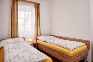 Duas camas num pequeno quarto com uma janela em Ferien- & Kürbishof Majczan em Bad Radkersburg