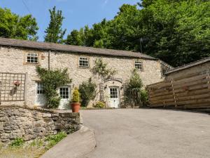 a stone building with a gate and a driveway at The Barn in Buxton