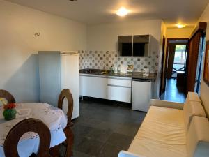 a kitchen with a table and a kitchen with a counter at Cumbuco Eco Paradise apto com varanda in Cumbuco