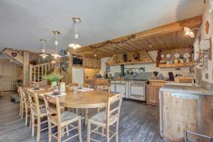 een keuken met een houten tafel en stoelen bij Chalet Cœur de Marie avec sauna et jacuzzi - Val d'Arly in Flumet