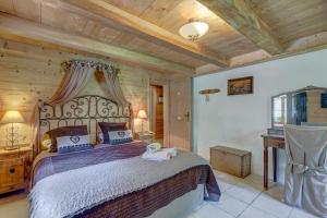 ein Schlafzimmer mit einem großen Bett und einer Holzdecke in der Unterkunft Chalet Cœur de Marie avec sauna et jacuzzi - Val d'Arly in Flumet