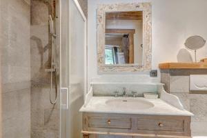 een badkamer met een wastafel en een spiegel en een douche bij Chalet Cœur de Marie avec sauna et jacuzzi - Val d'Arly in Flumet +16 foto's