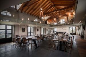 uma sala de jantar com mesas, cadeiras e janelas em Montalbera Wine Suites em Montemagno