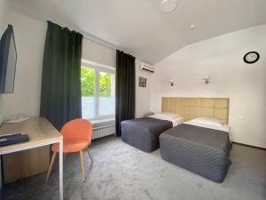 a bedroom with two beds and a desk and a desk at Hotel Uyut in Voronezh