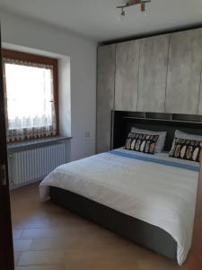 a bedroom with a large bed and a window at casa vacanze in Cogolo