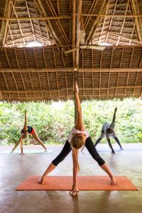 a group of people in a yoga class at Sunshine Marine Lodge in Matemwe