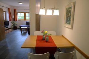 un comedor con una mesa y sillas con flores. en Haus Pichler Apartment en Collalbo