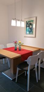 comedor con mesa roja y sillas en Haus Pichler Apartment, en Collalbo