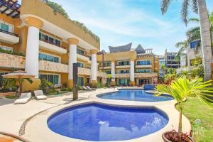 un complejo con piscina frente a un edificio en Fabulous Playa Getaway at 38th and Beach plus 2 Pools Onsite, en Playa del Carmen