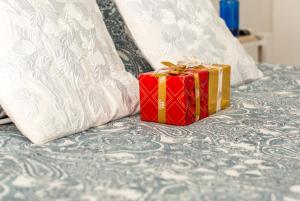 un regalo rojo sentado en la parte superior de una cama en Fuencarral Adeco, en Madrid