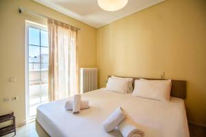 una camera da letto con un grande letto bianco con asciugamani sopra di Roma Apt by "elite" a Città di Zante