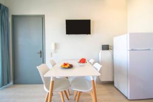 un tavolo bianco con sedie bianche e un frigorifero bianco di Roma Apt by "elite" a Città di Zante