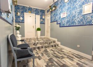 un pasillo con papel pintado azul y blanco y una silla en Fuencarral Adeco, en Madrid
