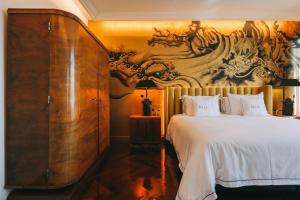 - une chambre avec un grand lit et une peinture murale dans l'établissement The Felix 10, à Lisbonne