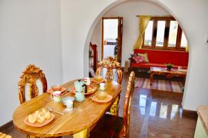 a wooden table with plates of food on it in a living room at Jasmin Villa in Hampi