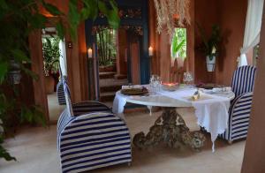 une salle à manger avec une table et des chaises blanches dans l'établissement Timamoon Lodge, à Hazyview