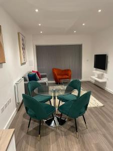 - un salon avec des chaises vertes et une table en verre dans l'établissement DREAMS APARTMENTS 2 BED, à Woolwich