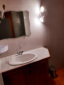 a bathroom with a sink and a mirror at Maison des trois ormeaux in Cier-de-Luchon