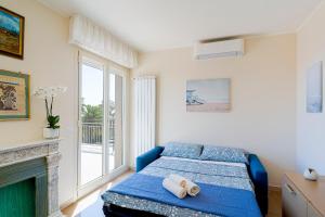 ein Schlafzimmer mit einem blauen Bett und einem Kamin in der Unterkunft Tre Ponti Panoramic Seaview Apartment in Sanremo