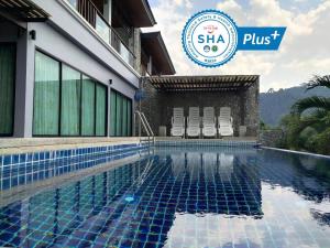 a hotel with a swimming pool and the sha plus logo at The Phura Villa Khaolak - SHA Extra Plus in Khao Lak