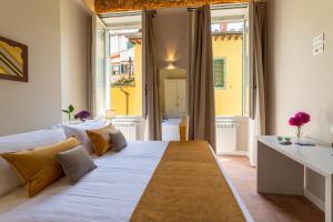 duże łóżko w pokoju z dużym oknem w obiekcie Atelier delle Grazie we Florencji