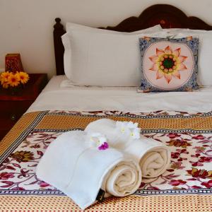 a bed with towels and flowers on top of it at Jasmin Villa in Hampi