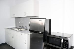 a kitchen with a stainless steel refrigerator and a microwave at Mavs Boutique At Ponce in Ponce