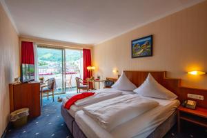 ein Hotelzimmer mit großem Bett und Balkon in der Unterkunft Moselstern Hotel Brixiade &Triton in Cochem
