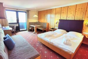 シュピーゲラウにあるHotel & Residence Hochriegelの大きなベッドとテーブルが備わるホテルルームです。