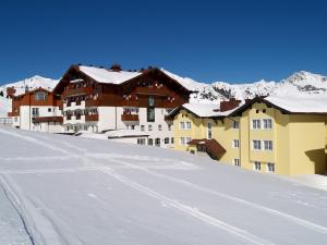 a group of buildings on a snow covered slope at Hotel Schneider Dependance in Obertauern