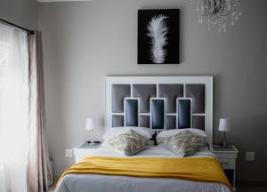 a bedroom with a large bed with two pillows at If Not Why Not Guesthouse in Potchefstroom