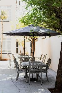 a table and chairs with an umbrella on a patio at If Not Why Not Guesthouse in Potchefstroom